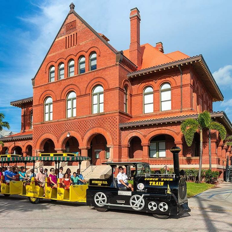 Conch Tour Train driving past customs house